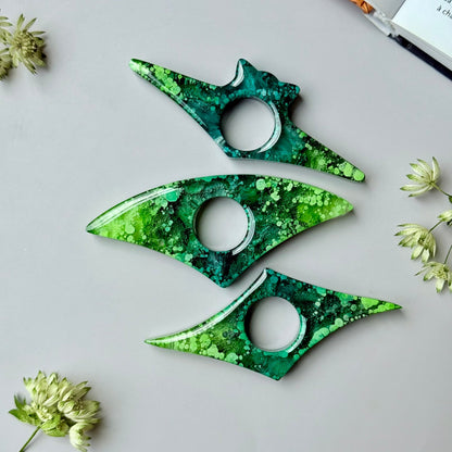 Handmade resin page holders with green and teal petri effect, displayed flat on a neutral background with dried flowers.